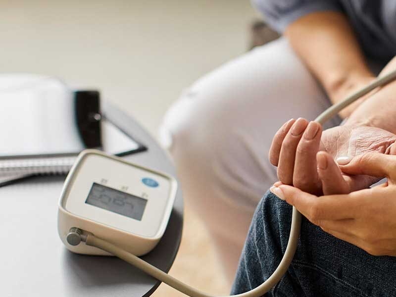 Person undergoing cardiac monitoring with a blood pressure device during rehabilitation.